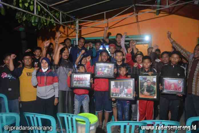 boks_rsz BERIKAN SEMANGAT: Warga saat nonton bareng laga final sepakbola SEA Games Filipina antara timnas Indonesia dan Vietnam di halaman rumah orangtua kapten Timnas U-23 Andy Setyo Nugroho. (Agus Hadianto/RADARSEMARANG.COM)
