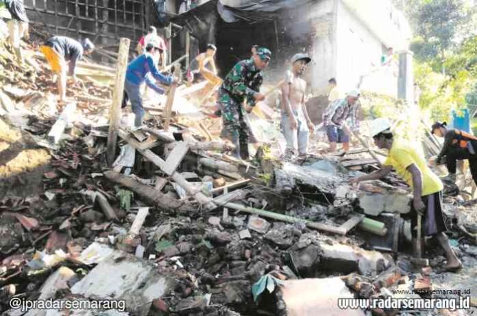 RATA: Warga Desa Sawangan, Kecamatan Paninggaran, bersama petugas Polres Pekalongan dan TNI membersihkan rumah warga yang terkena longsor, dan rata dengan tanah. (ISTIMEWA)