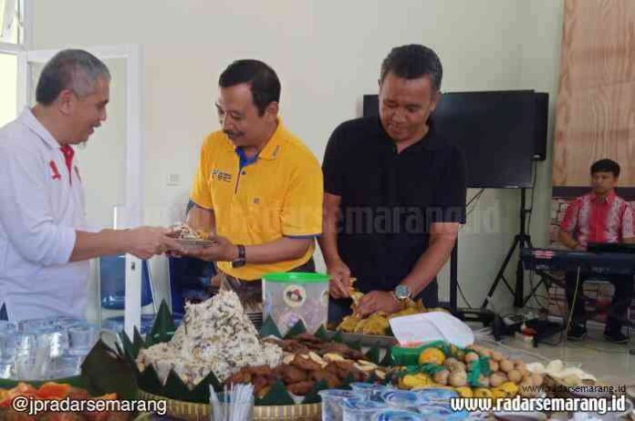TASYAKURAN : Sekda Wonosobo One AndangWardoyo memberikan potongan tumpeng kepada Kadiskominfo Eko Suryantoro sebagai tanda penggunaan gedung baru. (Sigit Rahmanto/Radar Kedu)
