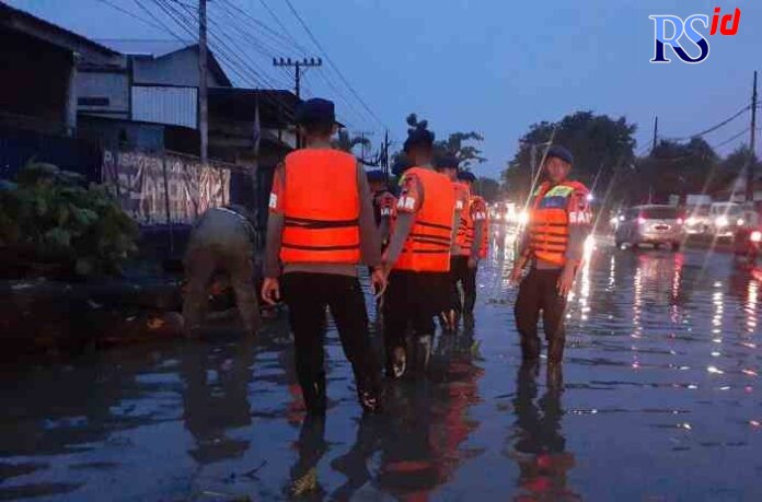 EVAKUASI POHON TUMBANG: Pohon tumbang dan jalan tergenang sempat membuat arus lalu lintas Jalan Pantura Kendal-Semarang tersendat, kemarin. (ADENNYAR WYCAKSONO/RADARSEMARANG.COM)